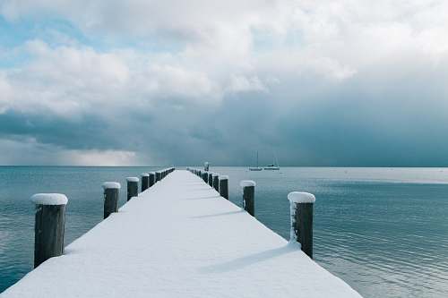 lake tahoe brown wooden dock covered with snow and body of water snow